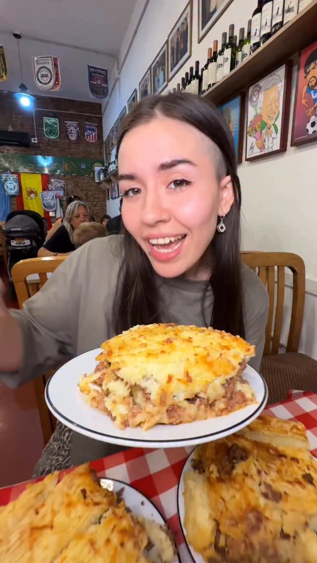 Comensal disfrutando una porción abundante de lasagna
